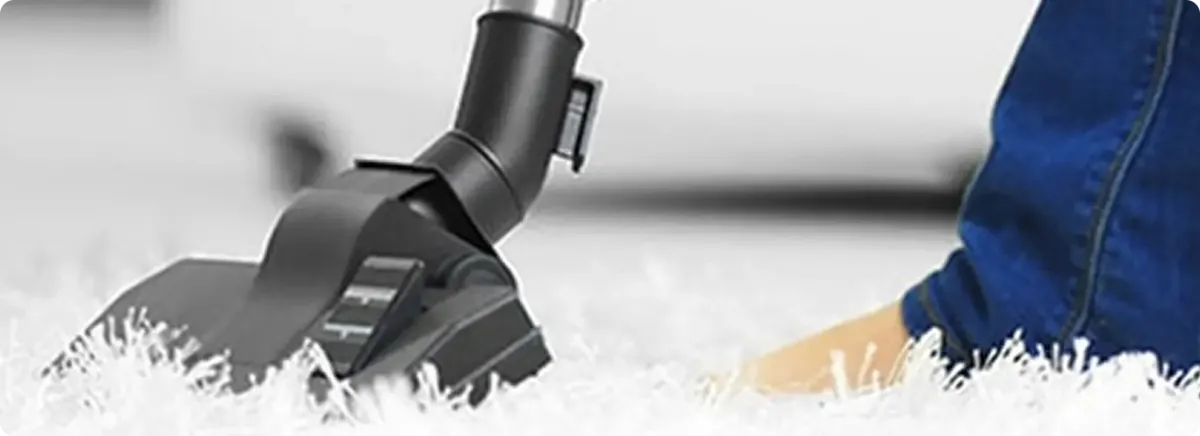 Close-up of a professional vacuuming a white carpet in Tualatin.